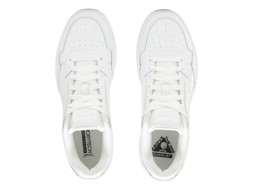 Tenis blancos Reebok de corte bajo con suela plana y cordones.