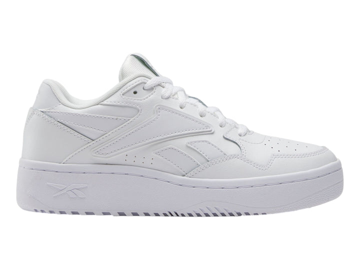 Tenis deportivos Reebok color blanco para niños, con suela ancha y diseño clásico de cuero sintético.