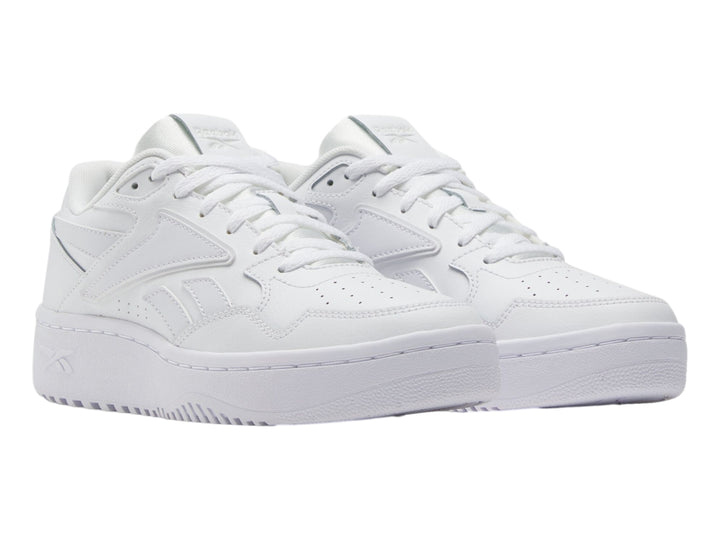 Tenis deportivos Reebok color blanco para niños, con suela ancha y diseño clásico de cuero sintético.