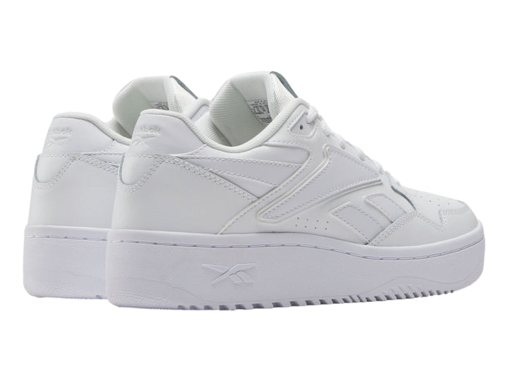Tenis deportivos Reebok color blanco para niños, con suela ancha y diseño clásico de cuero sintético.