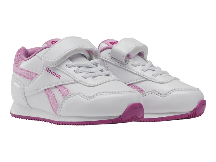 Tenis blancos Reebok para niña con detalles en rosa brillante y suela rosa.