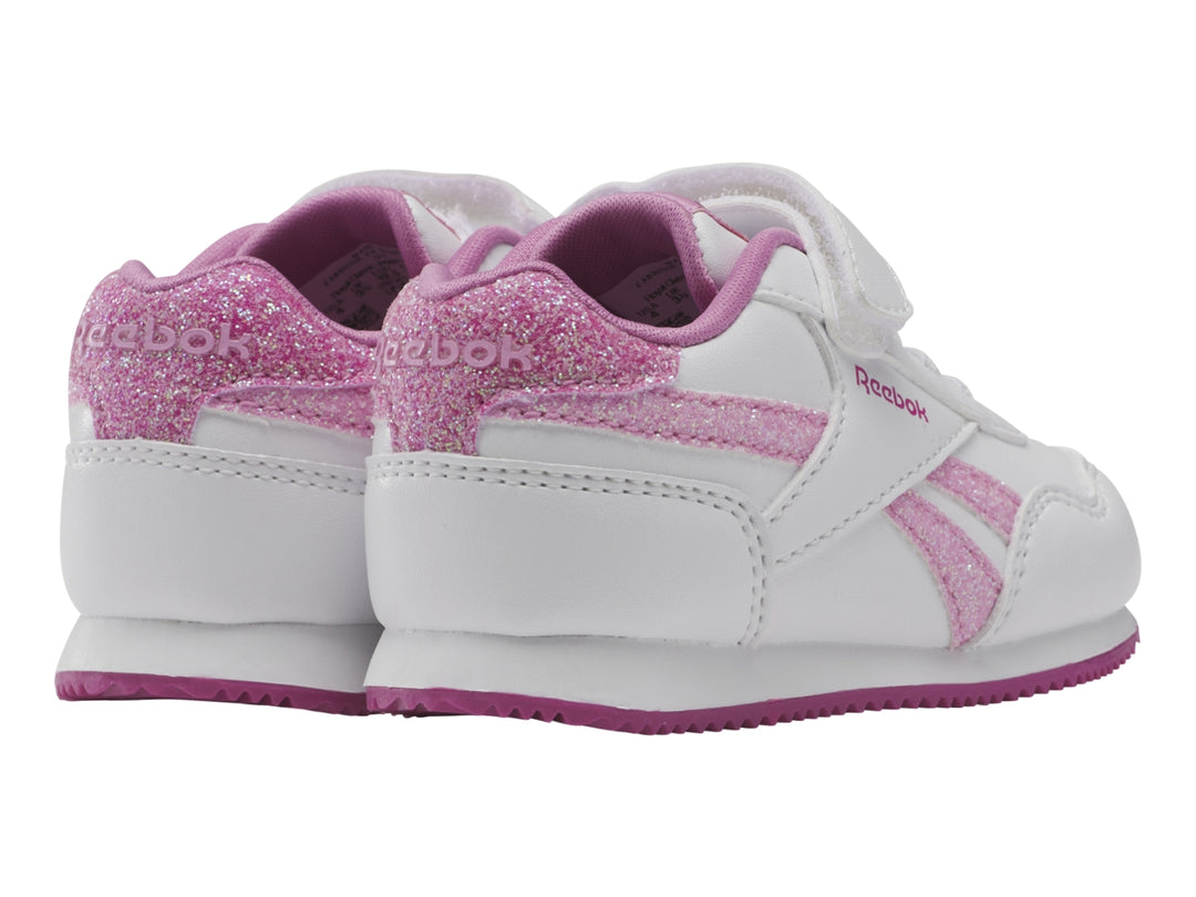 Tenis blancos Reebok para niña con detalles en rosa brillante y suela rosa.