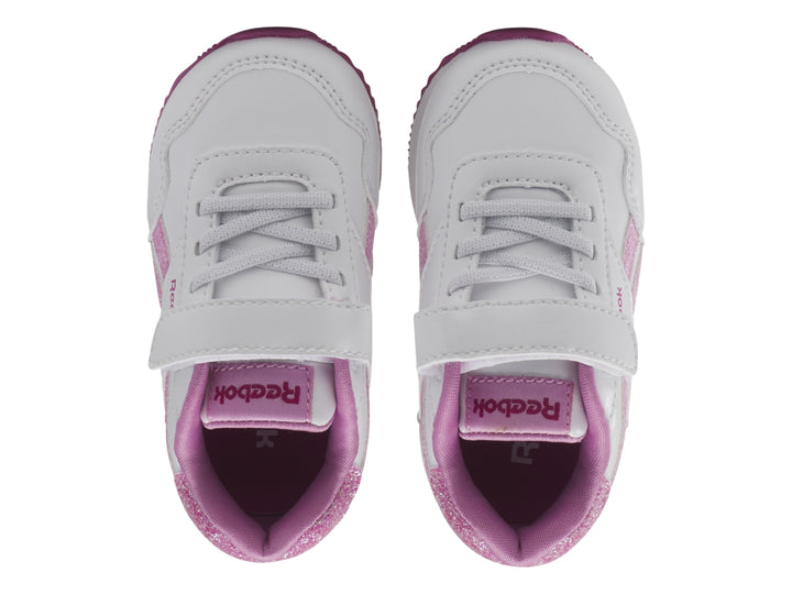 Tenis blancos Reebok para niña con detalles en rosa brillante y suela rosa.