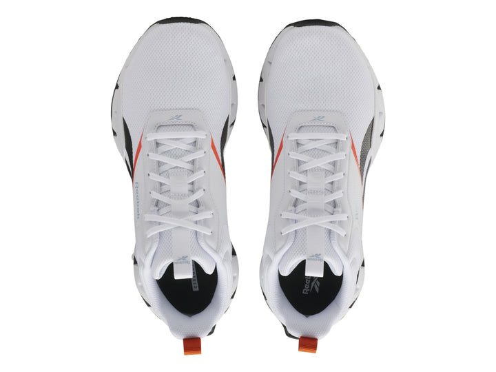 Tenis deportivos Reebok blancos con detalles negros y rojos y suela blanca con diseño zigzag.