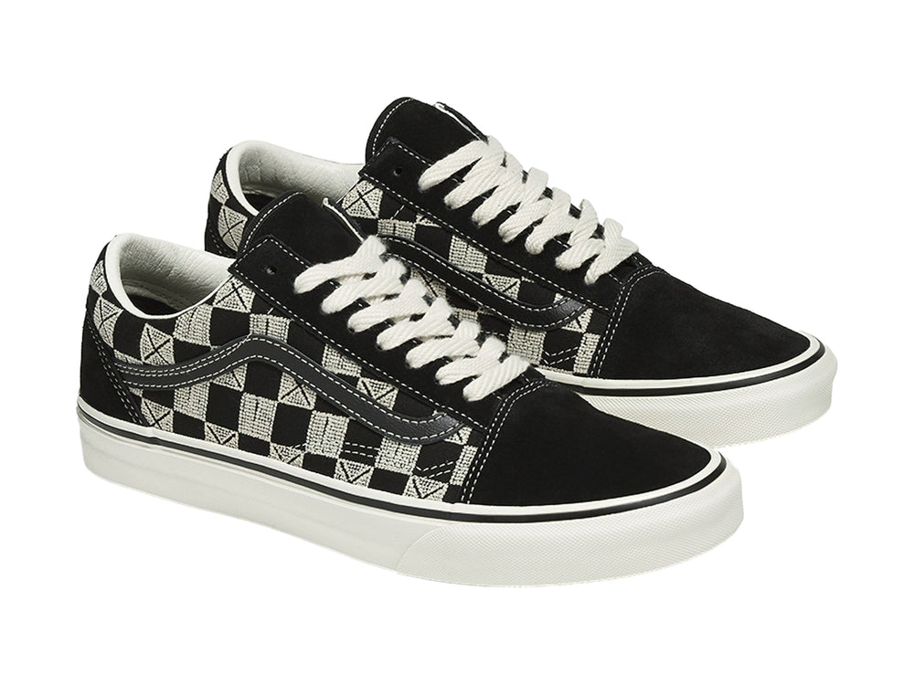 Tenis VANS Old Skool con diseño de cuadros en blanco y negro, suela blanca y agujetas blancas.