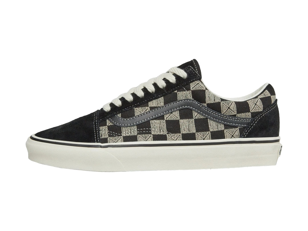 Tenis VANS Old Skool con diseño de cuadros en blanco y negro, suela blanca y agujetas blancas.