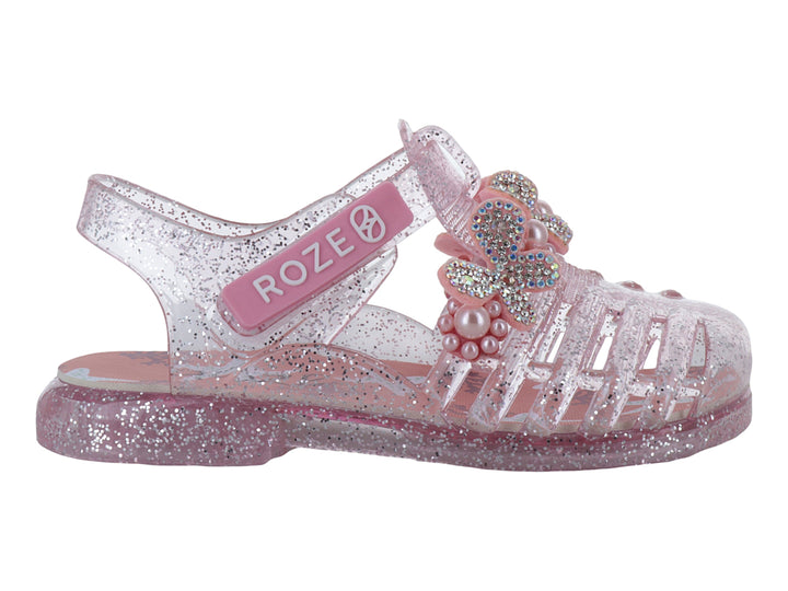 Sandalias infantiles color rosa con glitter, detalle de moño con perlas y correa ajustable marca ROZE.