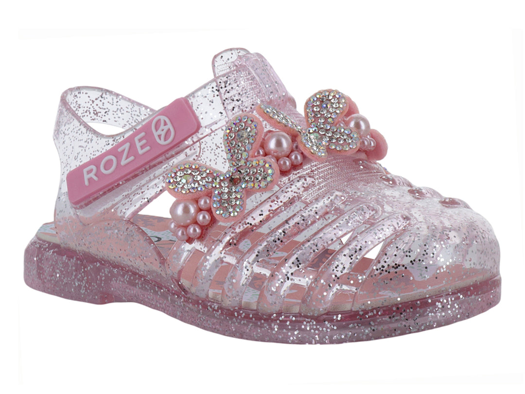 Sandalias infantiles color rosa con glitter, detalle de moño con perlas y correa ajustable marca ROZE.
