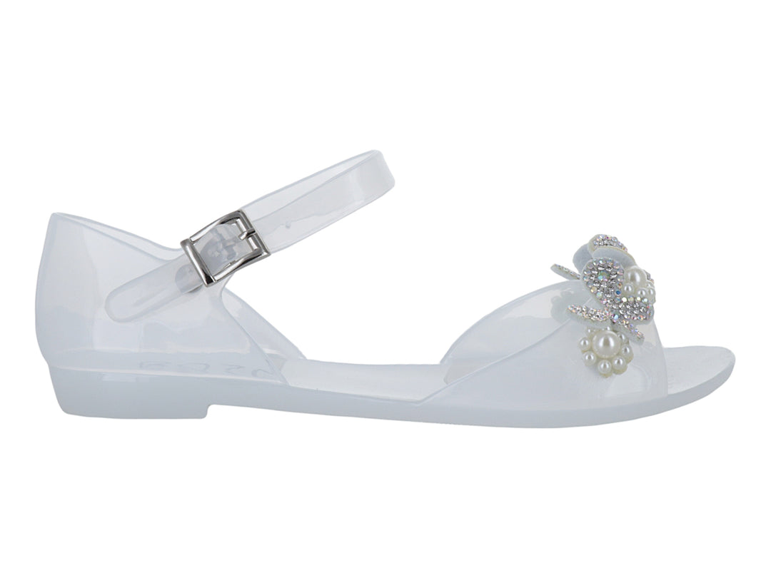 Sandalia blanca para niña con detalle de moño y perlas, correa ajustable y acabado brillante.
