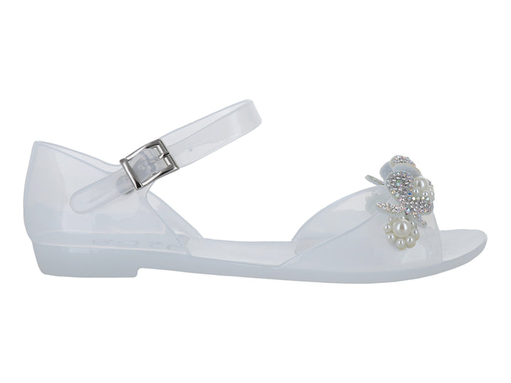 Sandalia blanca para niña con detalle de moño y perlas, correa ajustable y acabado brillante.
