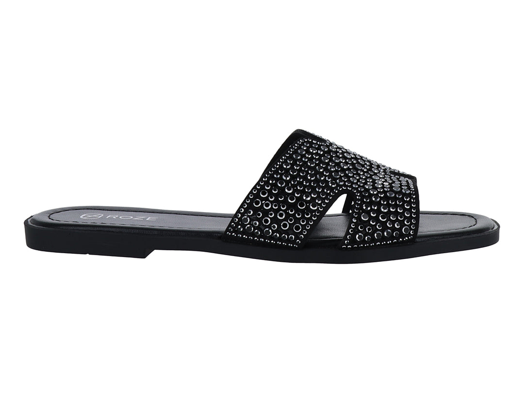 Sandalia slide color negro con correa ancha decorada con relieves circulares.