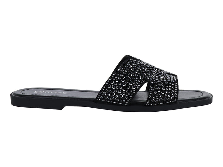 Sandalia slide color negro con correa ancha decorada con relieves circulares.