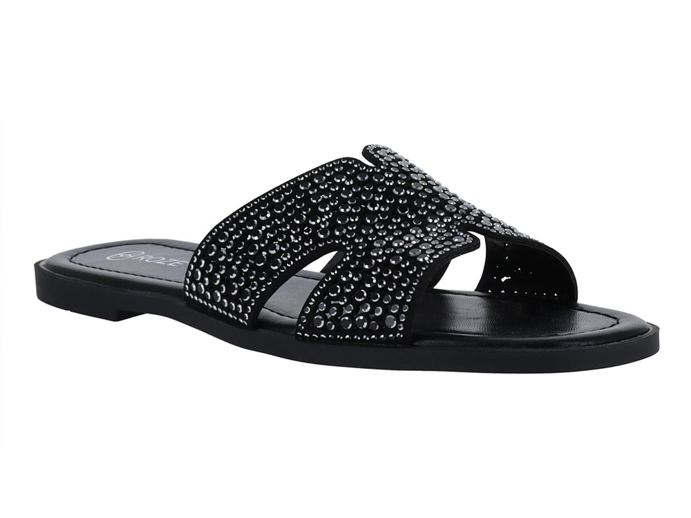 Sandalia slide color negro con correa ancha decorada con relieves circulares.