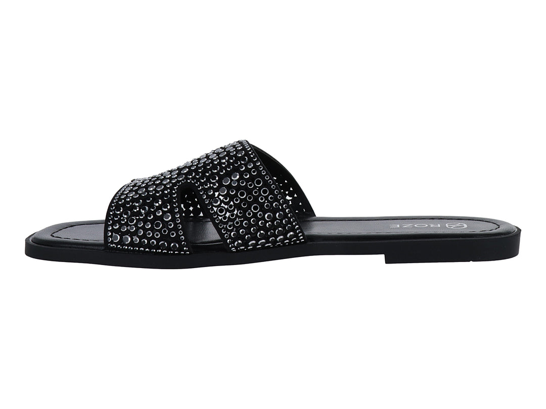 Sandalia slide color negro con correa ancha decorada con relieves circulares.