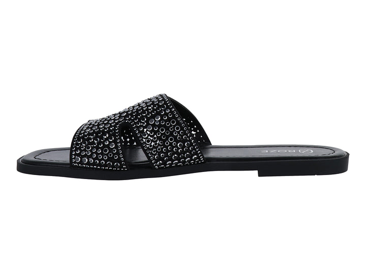 Sandalia slide color negro con correa ancha decorada con relieves circulares.