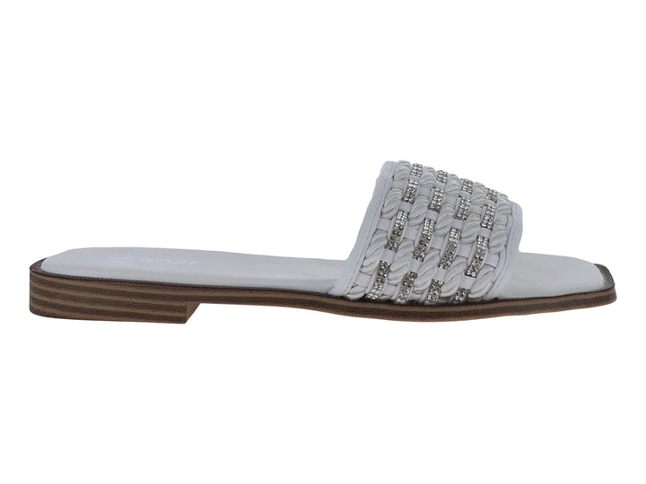 Sandalia blanca con tira trenzada y detalles brillantes, suela café con rayas horizontales.