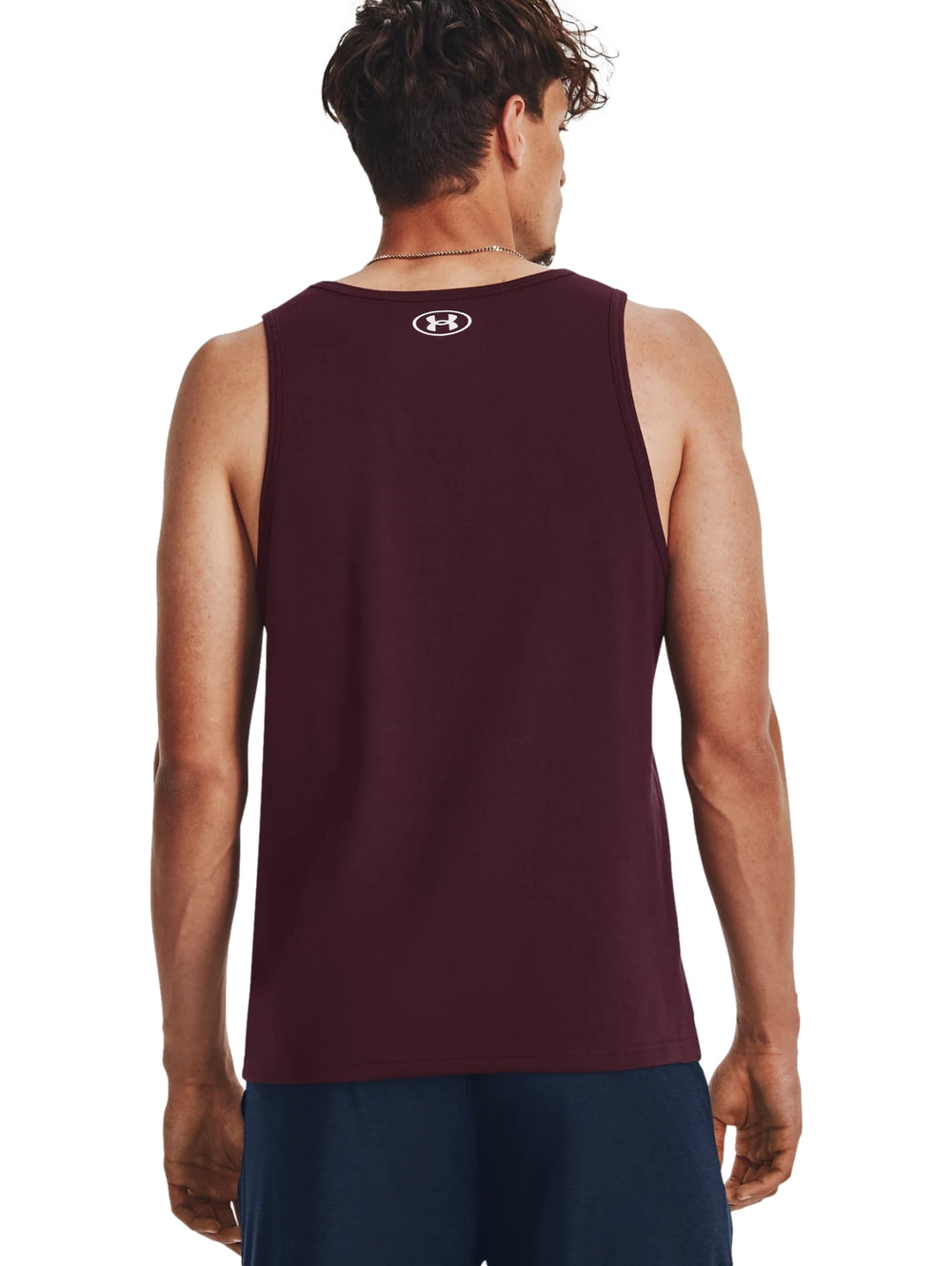 Hombre vistiendo una camiseta sin mangas color maroon de Under Armour con logo blanco en el pecho.