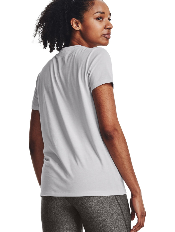 Mujer vistiendo una camiseta deportiva gris de manga corta con logo de Under Armour en el pecho.