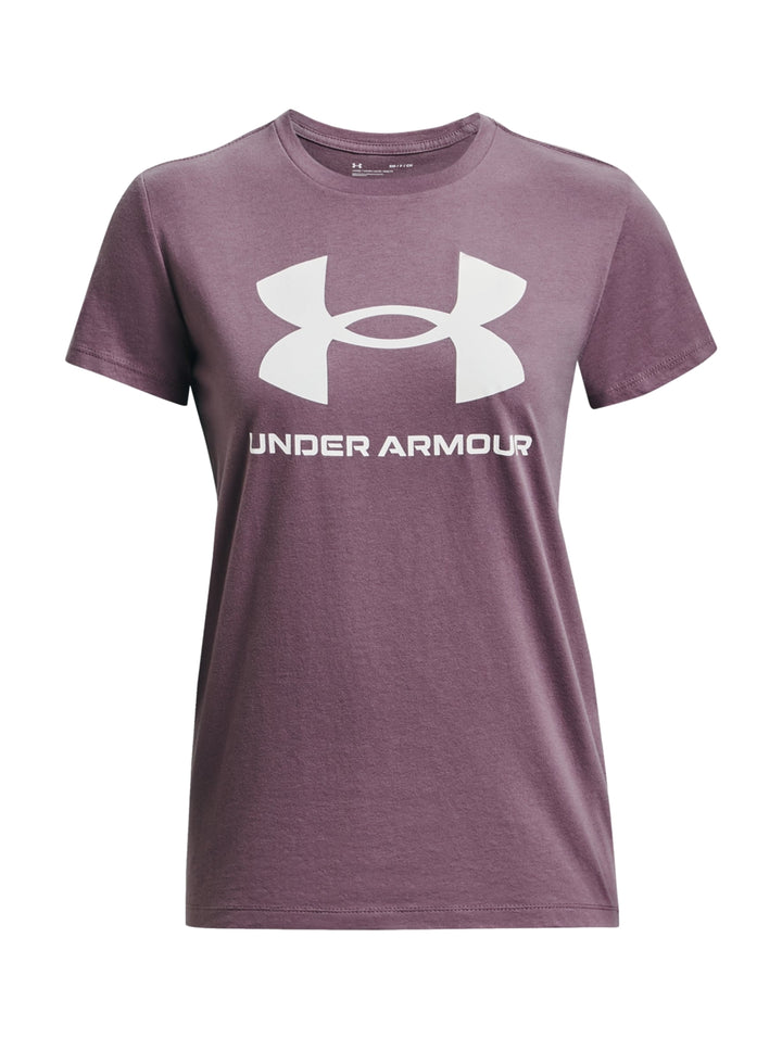 Mujer vistiendo camiseta deportiva morada de manga corta con logo blanco de Under Armour y shorts grises.