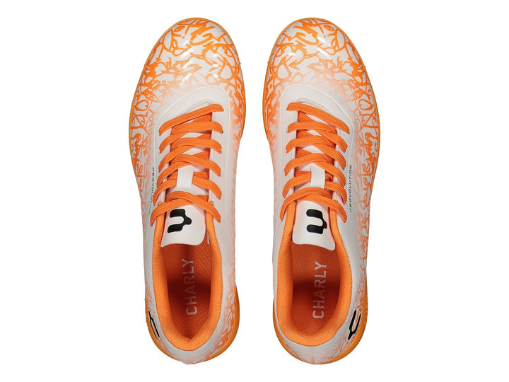 Zapato de fútbol Charly color blanco con detalles y suela naranja, diseño sintético para cancha Turf.