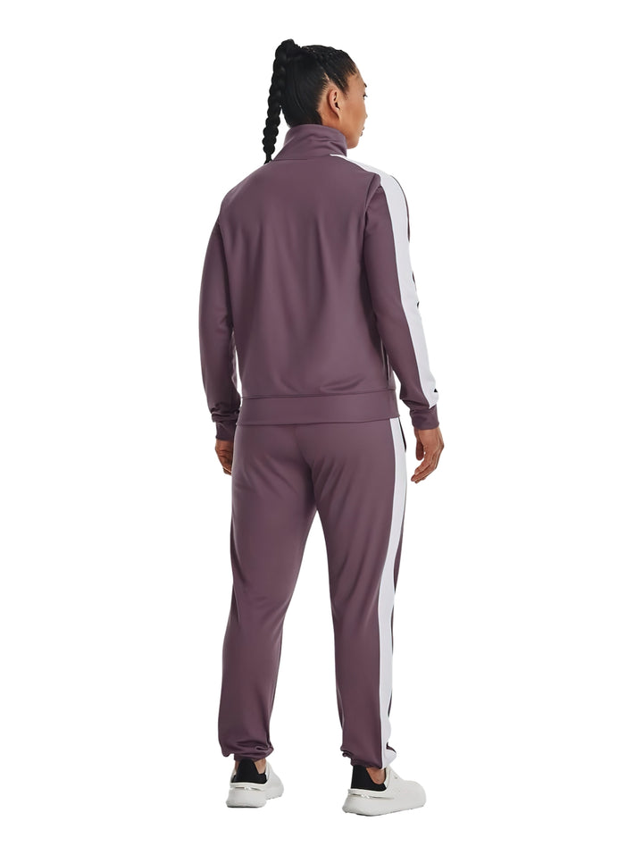 Mujer vistiendo un conjunto deportivo Under Armour de color morado con detalles blancos.