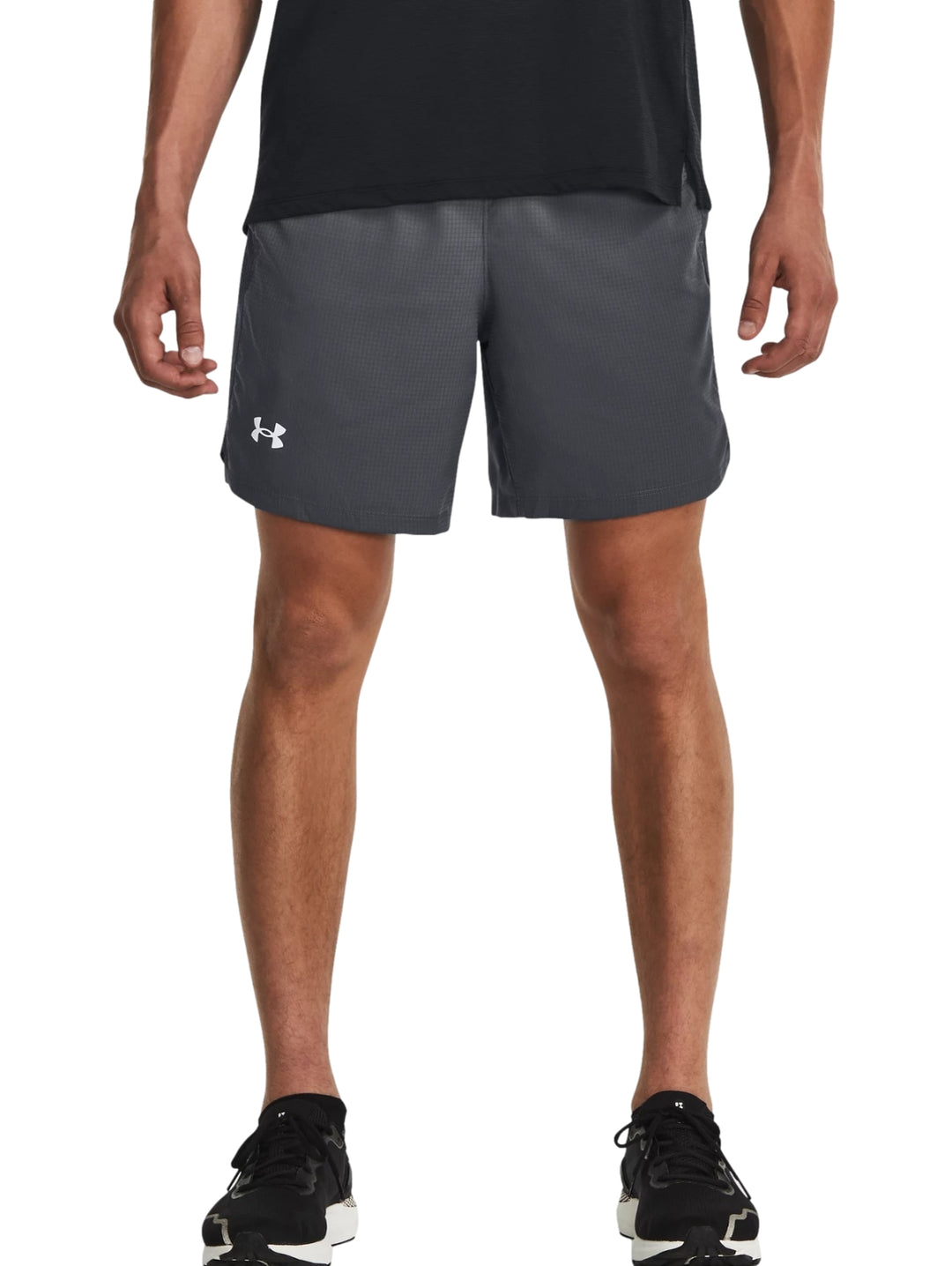 Hombre vistiendo shorts deportivos color gris de la marca Under Armour.