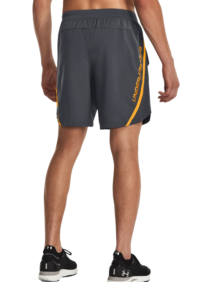 Hombre vistiendo shorts deportivos color gris de la marca Under Armour.
