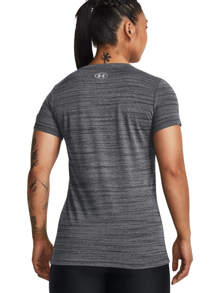 Mujer vistiendo camiseta deportiva Under Armour de color negro jaspeado con manga corta y cuello redondo.