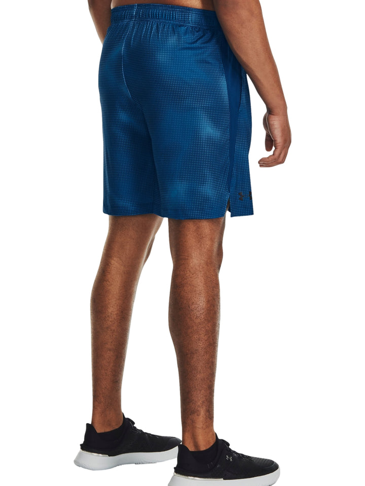Hombre vistiendo shorts deportivos color azul de la marca Under Armour con un patrón impreso.