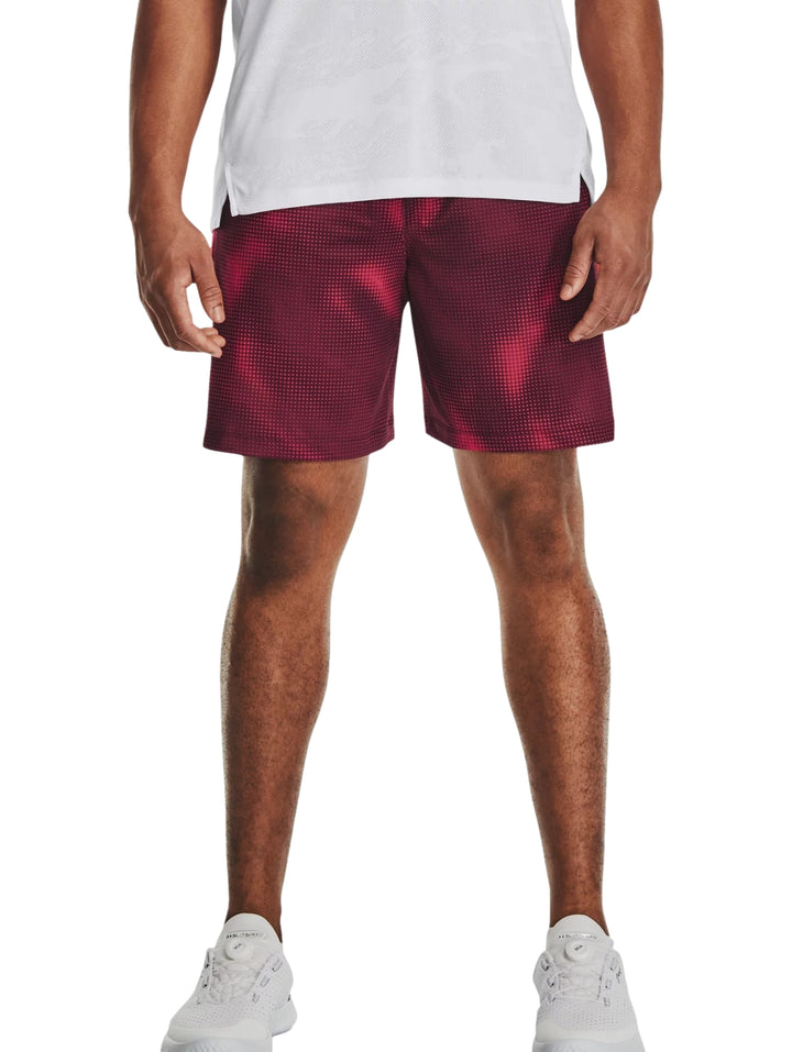 Hombre vistiendo pantalones cortos deportivos Under Armour color maroon con estampado de puntos.