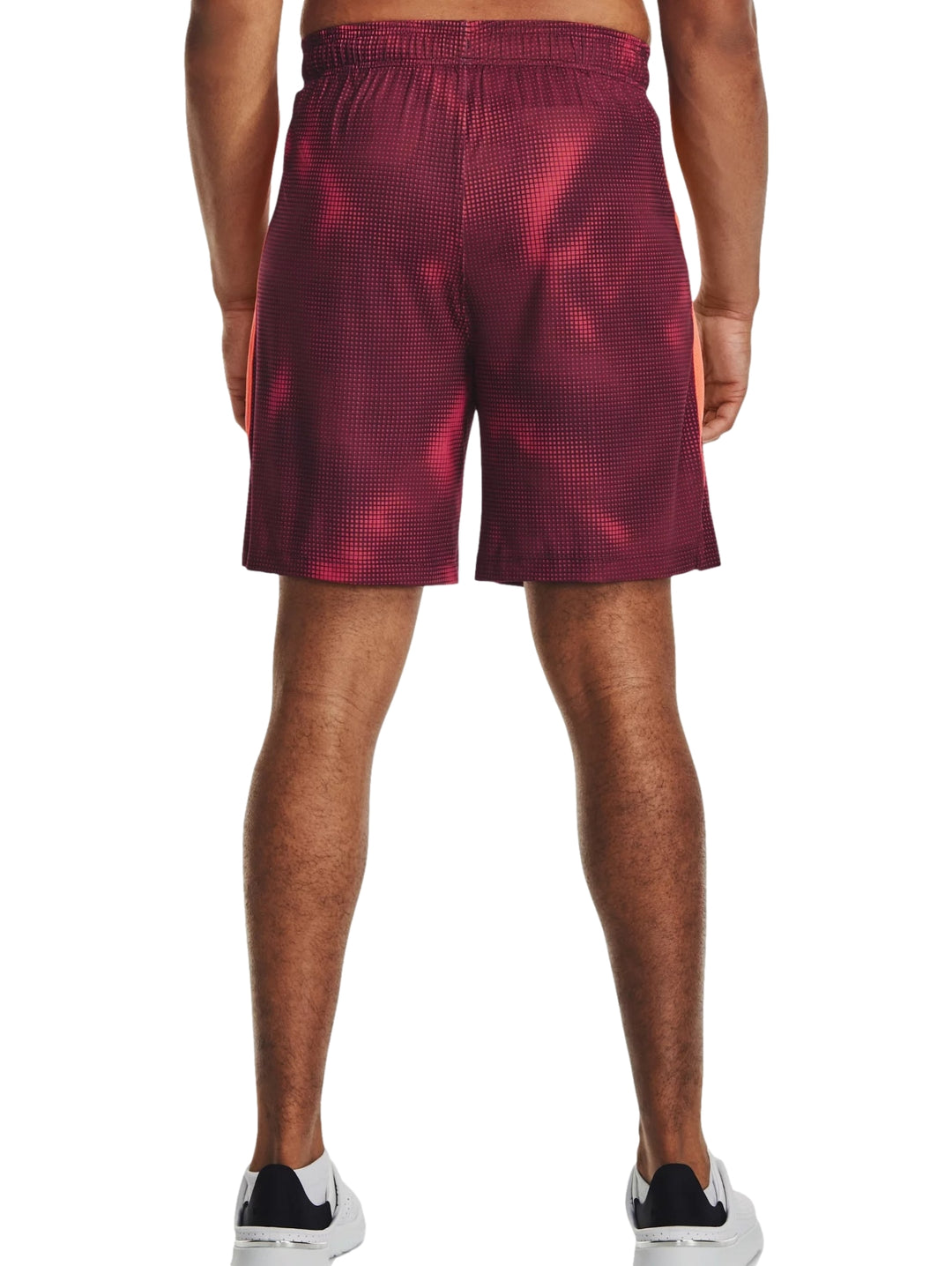 Hombre vistiendo pantalones cortos deportivos Under Armour color maroon con estampado de puntos.