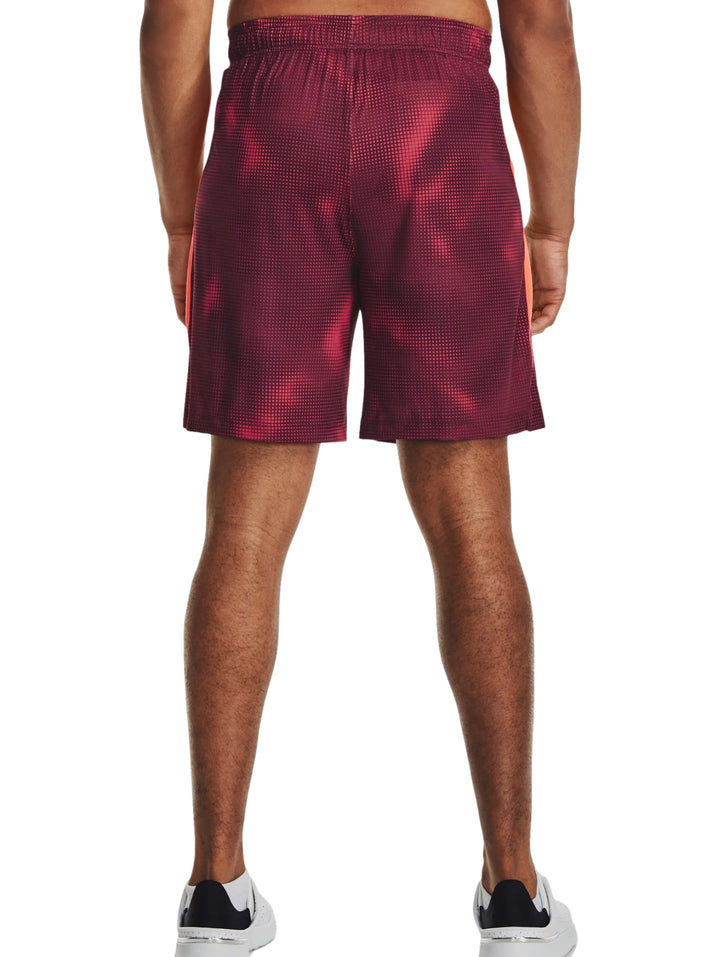 Hombre vistiendo pantalones cortos deportivos Under Armour color maroon con estampado de puntos.