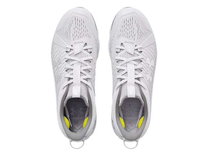 Zapato deportivo Under Armour blanco de corte bajo con tacos grises en la suela.