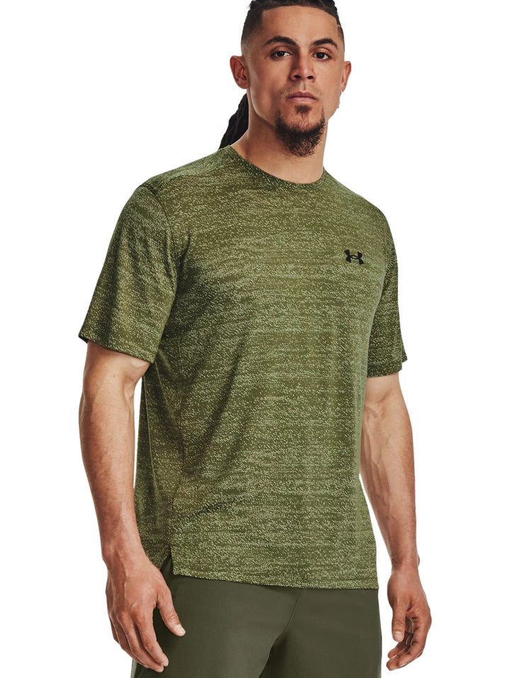Hombre usando camiseta deportiva de manga corta color amarillo lima jaspeado marca Under Armour.