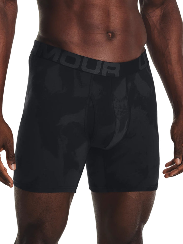 Hombre vistiendo bóxers deportivos Under Armour en color negro con patrón de camuflaje oscuro.
