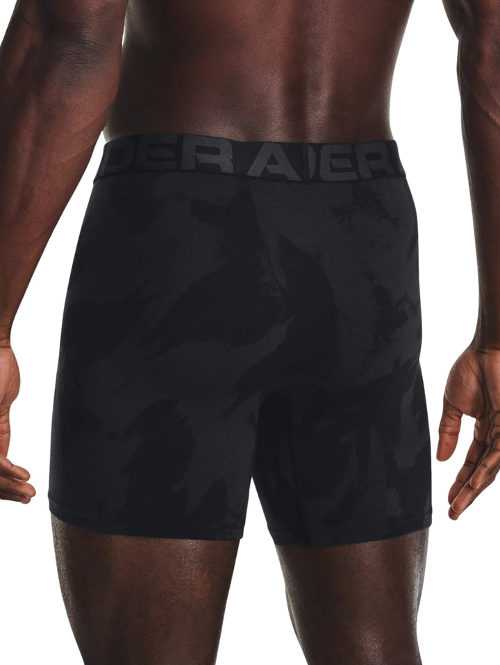 Hombre vistiendo bóxers deportivos Under Armour en color negro con patrón de camuflaje oscuro.