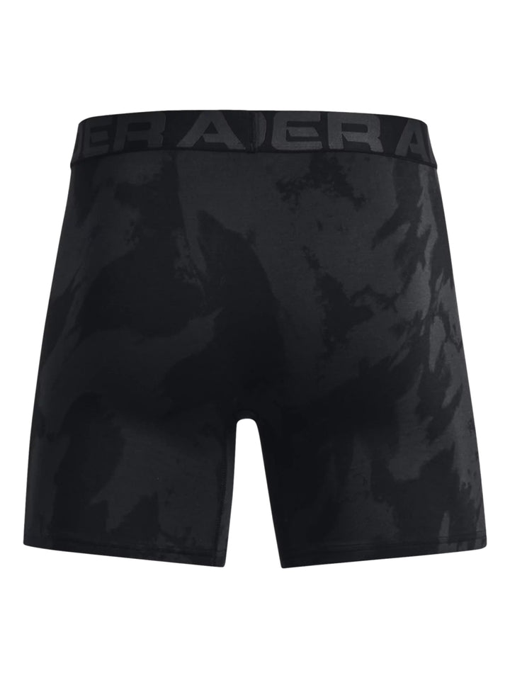 Hombre vistiendo bóxers deportivos Under Armour en color negro con patrón de camuflaje oscuro.