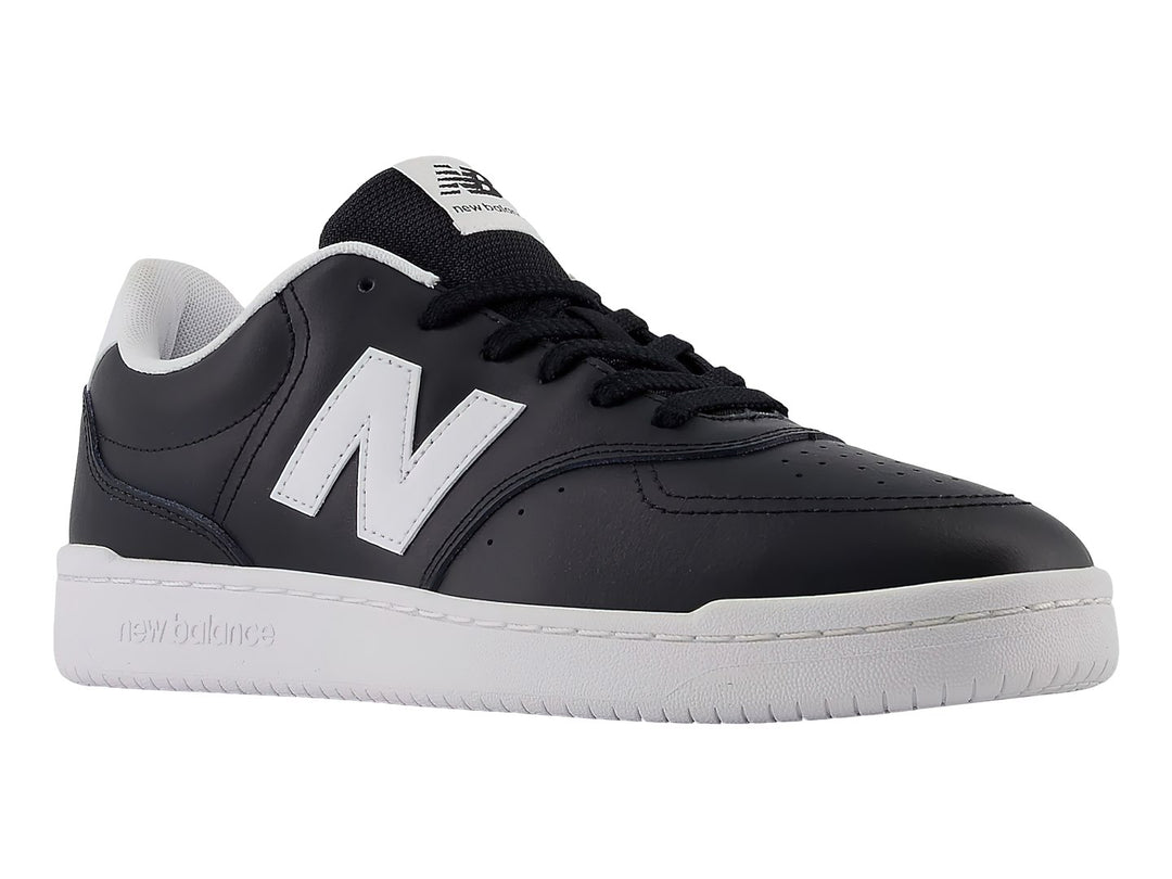 Tenis New Balance color negro con suela blanca y logotipo N en el costado.