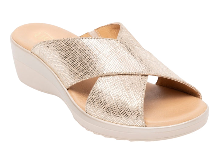 Sandalia Flexi color oro con diseño de tiras cruzadas y plataforma de cuña en tono beige.
