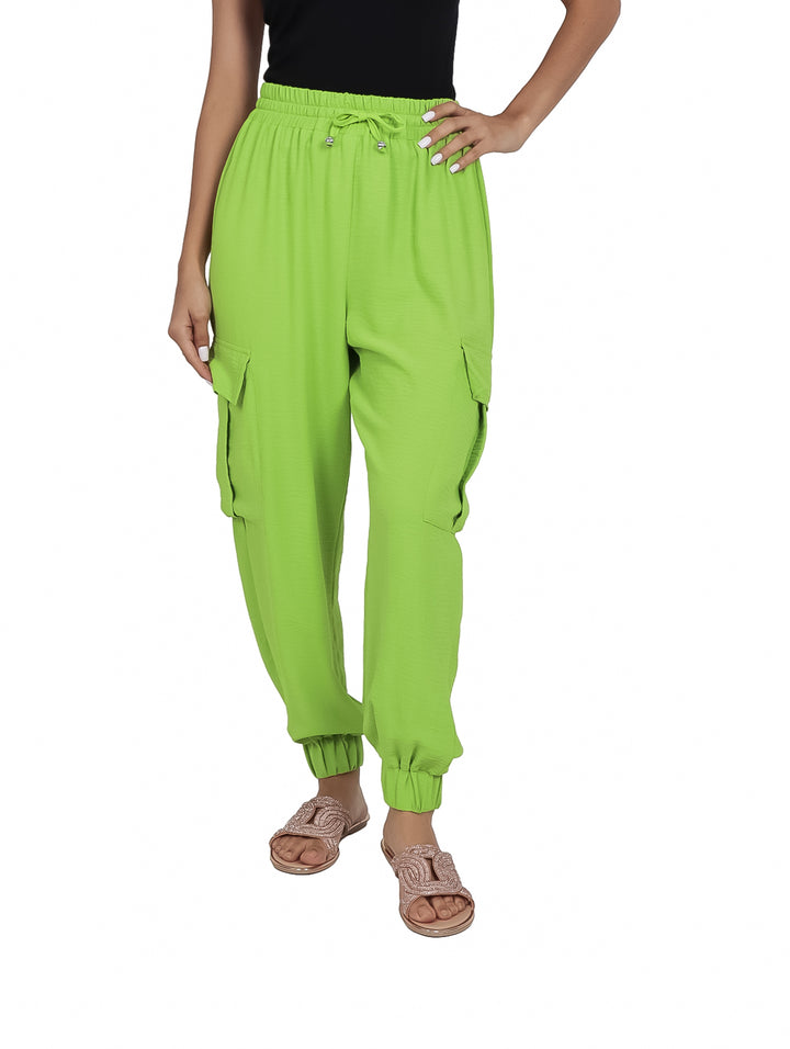 Mujer vistiendo pantalón cargo color verde kiwi con bolsillos laterales y cintura ajustable.
