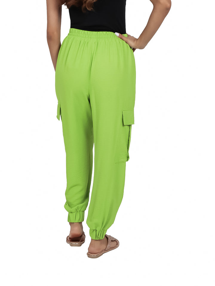 Mujer vistiendo pantalón cargo color verde kiwi con bolsillos laterales y cintura ajustable.