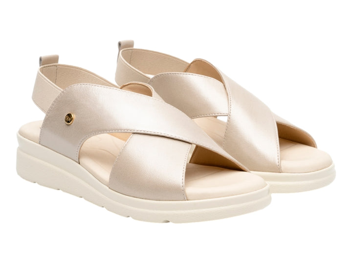 Sandalia color perla con tiras cruzadas y suela blanca para mujer.