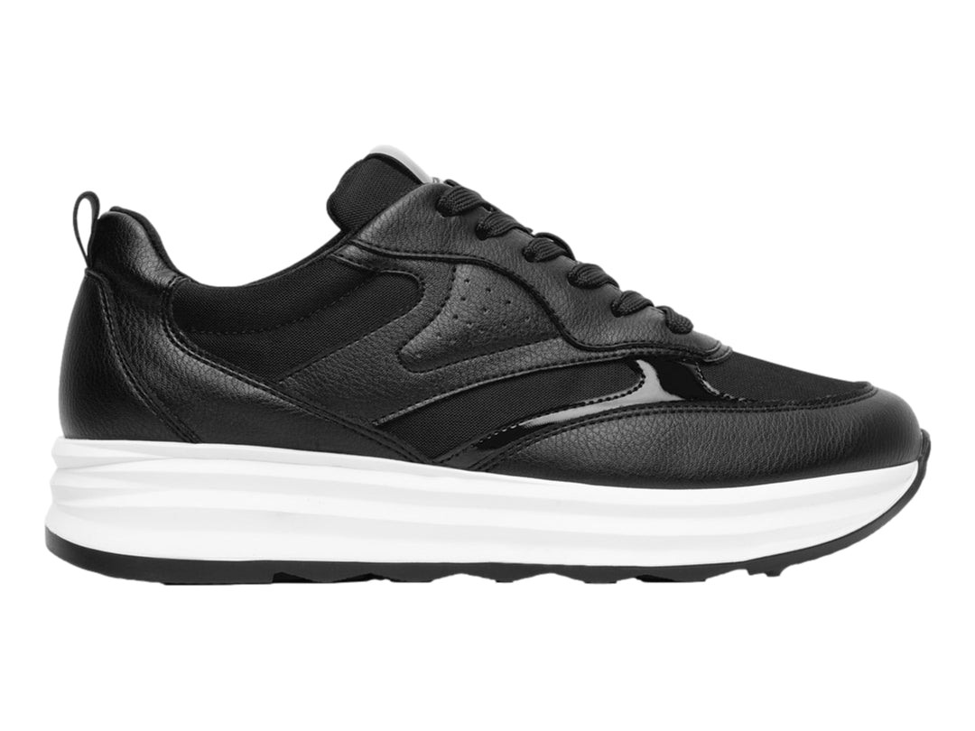 Tenis Flexi color negro con suela blanca gruesa y detalles en material sintético.