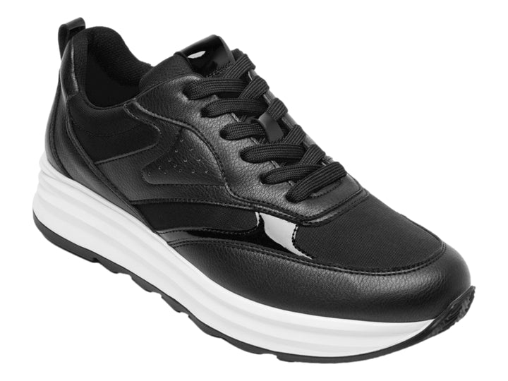 Tenis Flexi color negro con suela blanca gruesa y detalles en material sintético.