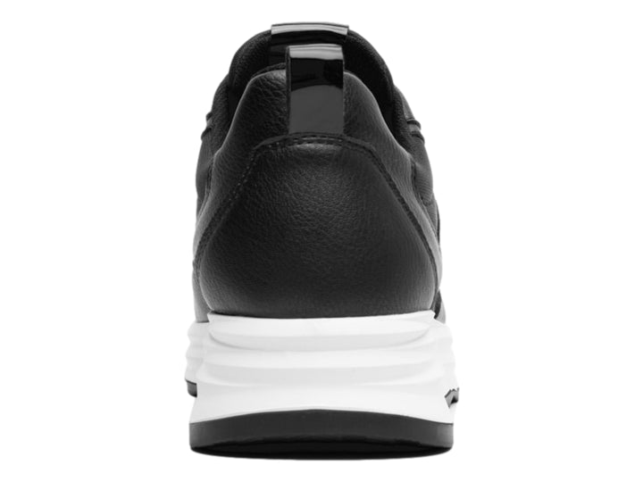 Tenis Flexi color negro con suela blanca gruesa y detalles en material sintético.
