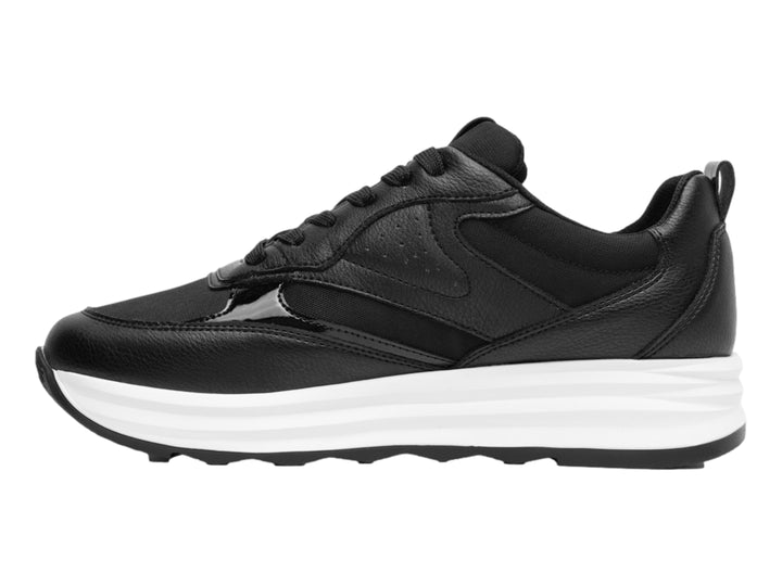 Tenis Flexi color negro con suela blanca gruesa y detalles en material sintético.