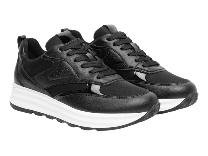 Tenis Flexi color negro con suela blanca gruesa y detalles en material sintético.
