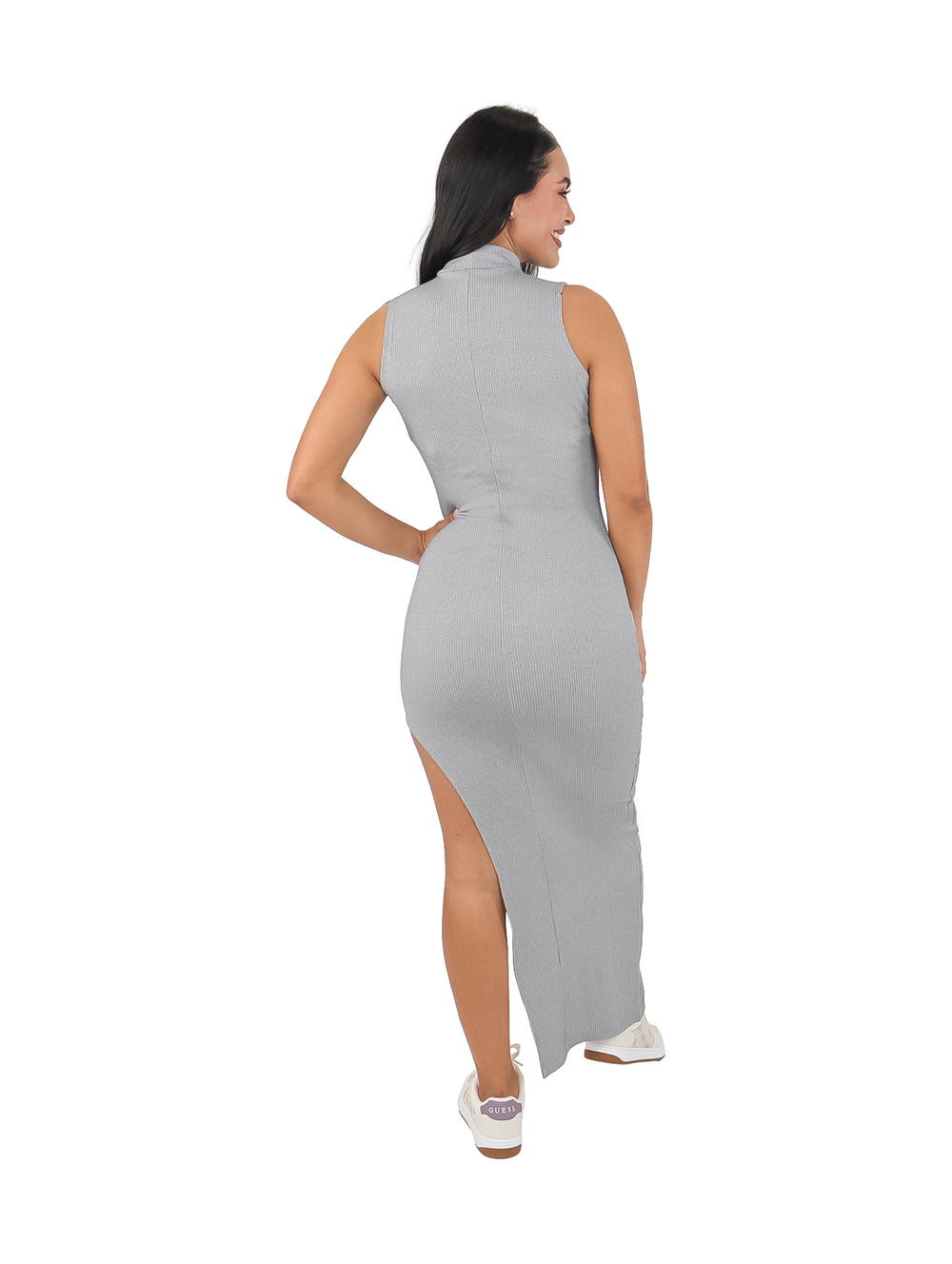 Mujer vistiendo un vestido largo ajustado color gris con cuello alto y abertura lateral en la pierna.