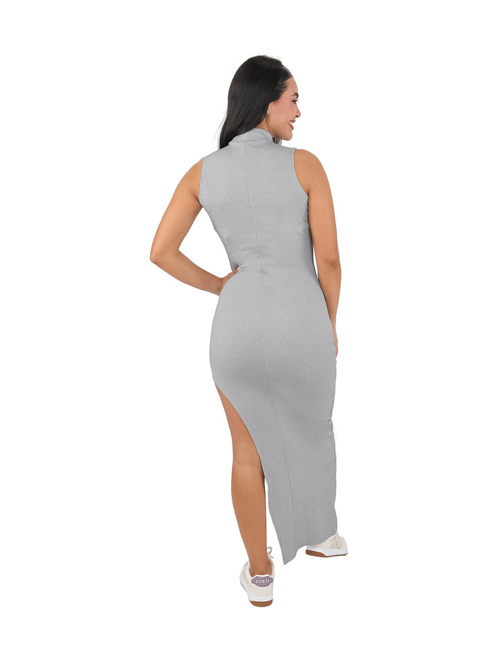 Mujer vistiendo un vestido largo ajustado color gris con cuello alto y abertura lateral en la pierna.
