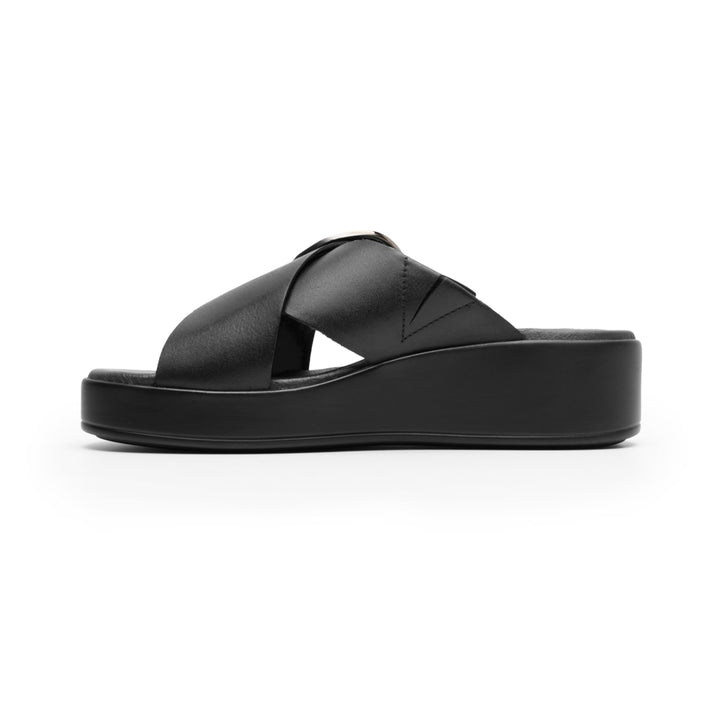 Sandalia de plataforma color negro con una hebilla circular metálica en la parte superior.